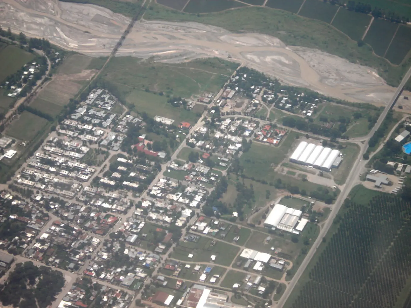 Vista aérea de Lules con sus manzanas, el río y las fincas alrededor